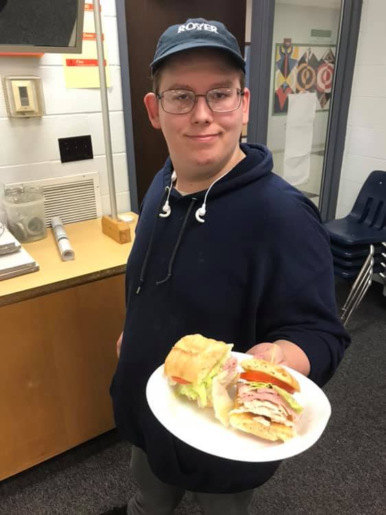 A Cub Culinary student displays a gourmet sandwich.