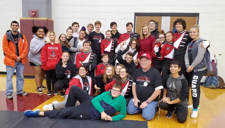 The+MCHS+Marching+Band+huddles+together+for+a+photo+opportunity+at+the+state+finals.