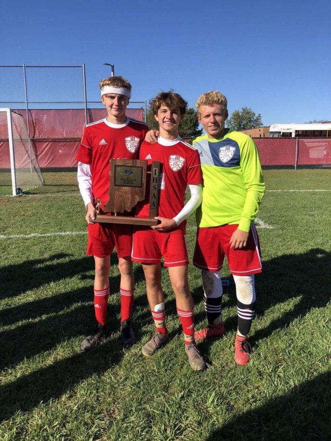 Juniors Smith, Zach Forner, and Will Heitz pose with the sectional championship trophy,