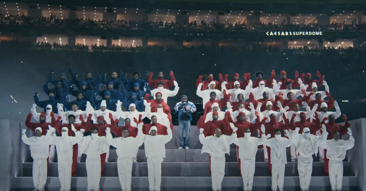 Kendrick Lamar stands in the middle of backup dancer assembled to resemble the American flag at Super Bowl LIX