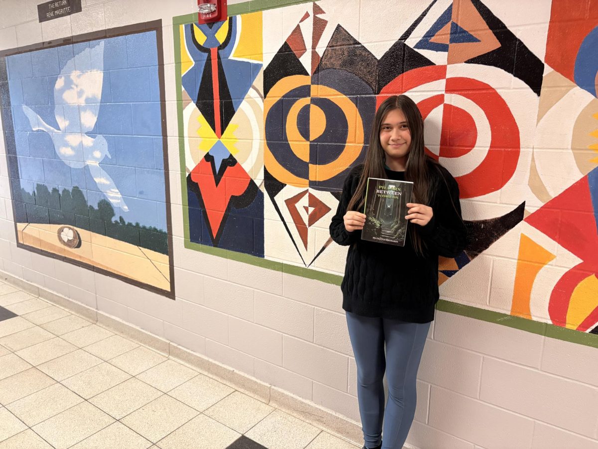 MCHS sophomore Makayla Richards poses with her published novel 'Pillars Between Worlds'.